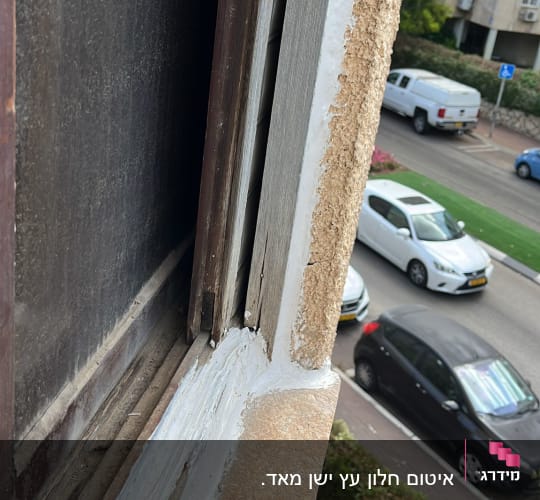 איטום חלון עם חומר לבן על מסגרת עץ
